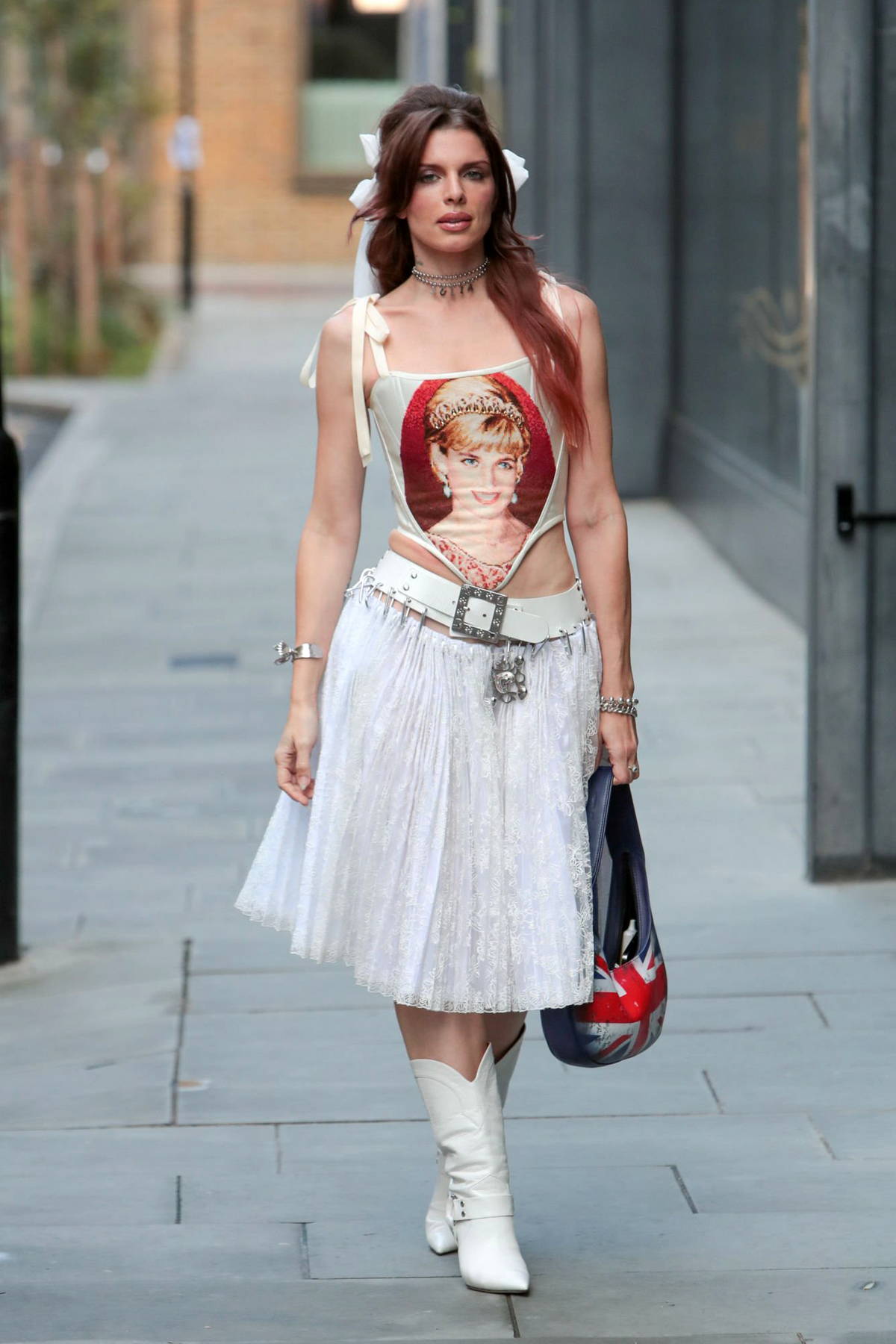 Julia Fox wears 'Princess Diana' print corset top with a white skirt and boots while stepping out in London, UK