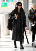 Camila Cabello stays cozy in a leather trench coat and headphones as she arrives at LaGuardia Airport in New York City