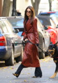 Emily Ratajkowski looks chic in a burgundy leather coat as she takes her dog out for a walk in New York City