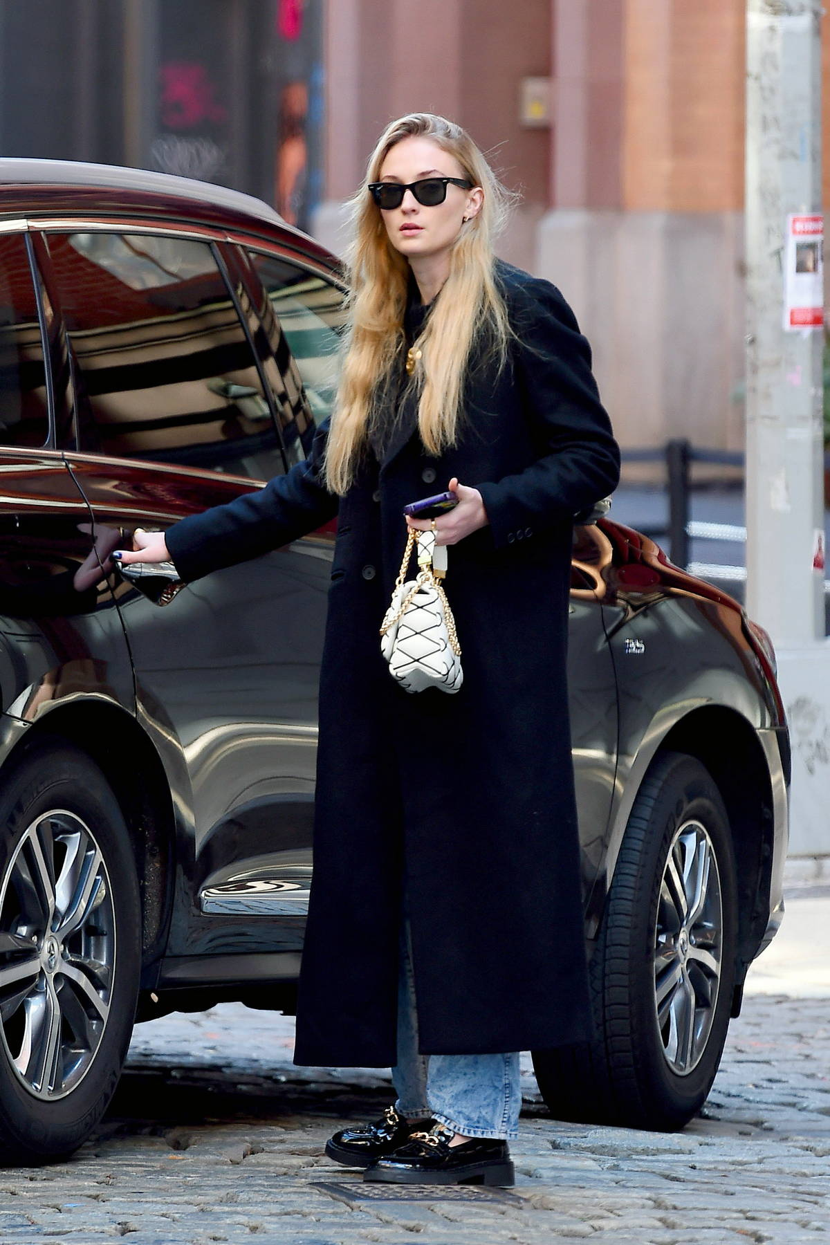 Sophie Turner wore a black trench coat, jeans and black loafers while out in New York City