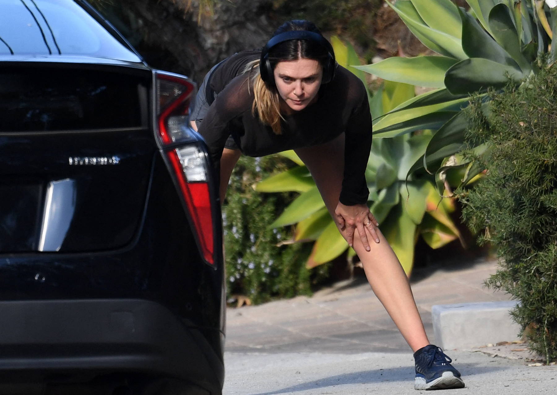 Elizabeth Olsen sweats it out in a see-through top over sports bra and  shorts during