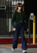 Kaia Gerber wears a green cardigan and baggy jeans while visiting a beauty salon in Beverly Hills, California