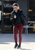 Lucy Hale sports a black crop top with maroon leggings while