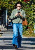 Lucy Hale wears a green jacket paired with blue jeans while stepping out after having lunch at All Time in Los Feliz, California