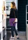 Alessandra Ambrosio rocks a black sweater with purple leggings
