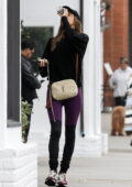 Alessandra Ambrosio rocks a black sweater with purple leggings