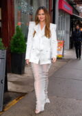 Chrissy Teigen looks chic in a white blazer with a see-through maxi skirt during a lunch outing a Vietnamese restaurant in New York City