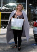 Hilary Duff shows off her curves in a mauve tank top and black leggings  while shopping groceries at Jayde's in Los Angeles