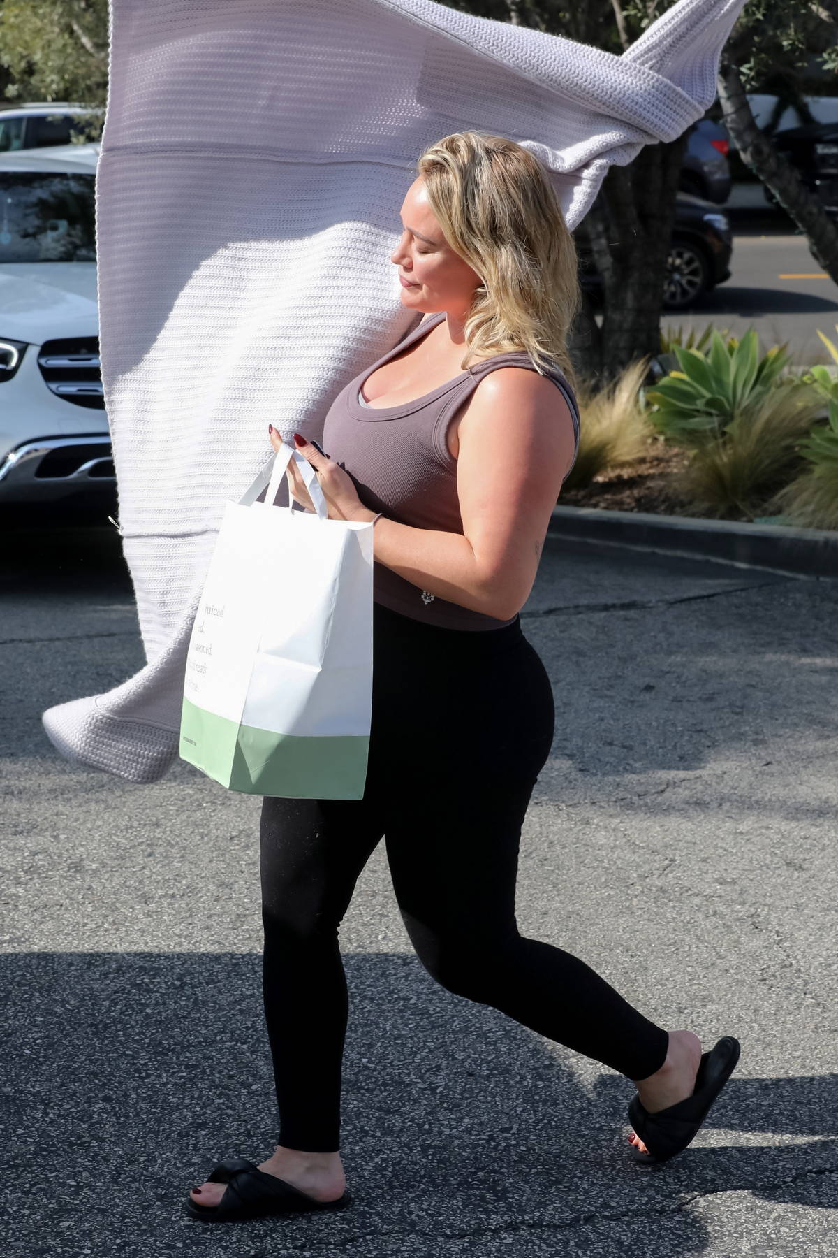 Hilary Duff shows off her curves in a mauve tank top and black