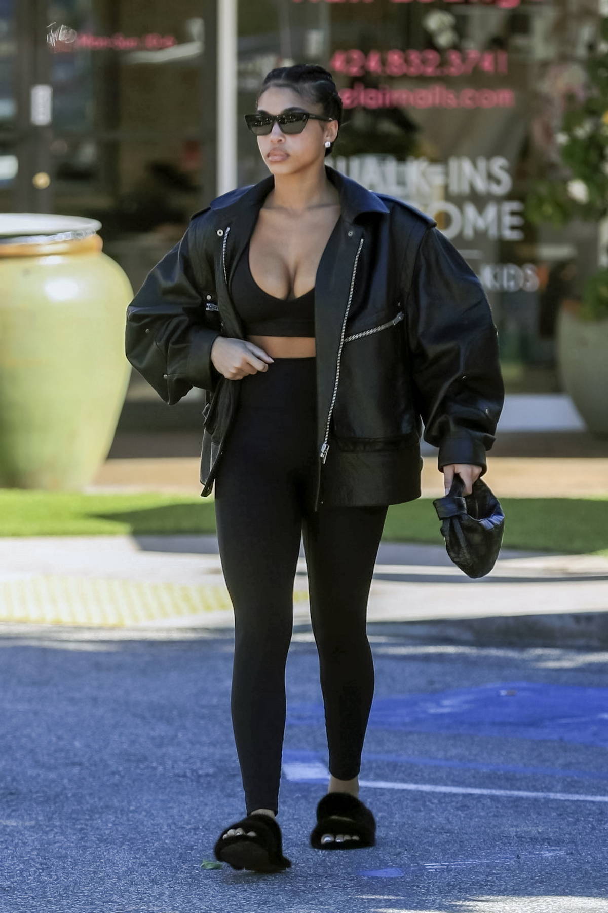 Lori Harvey sports a black sports bra and leggings with leather jacket while stopping for a post-workout smoothie in Los Angeles