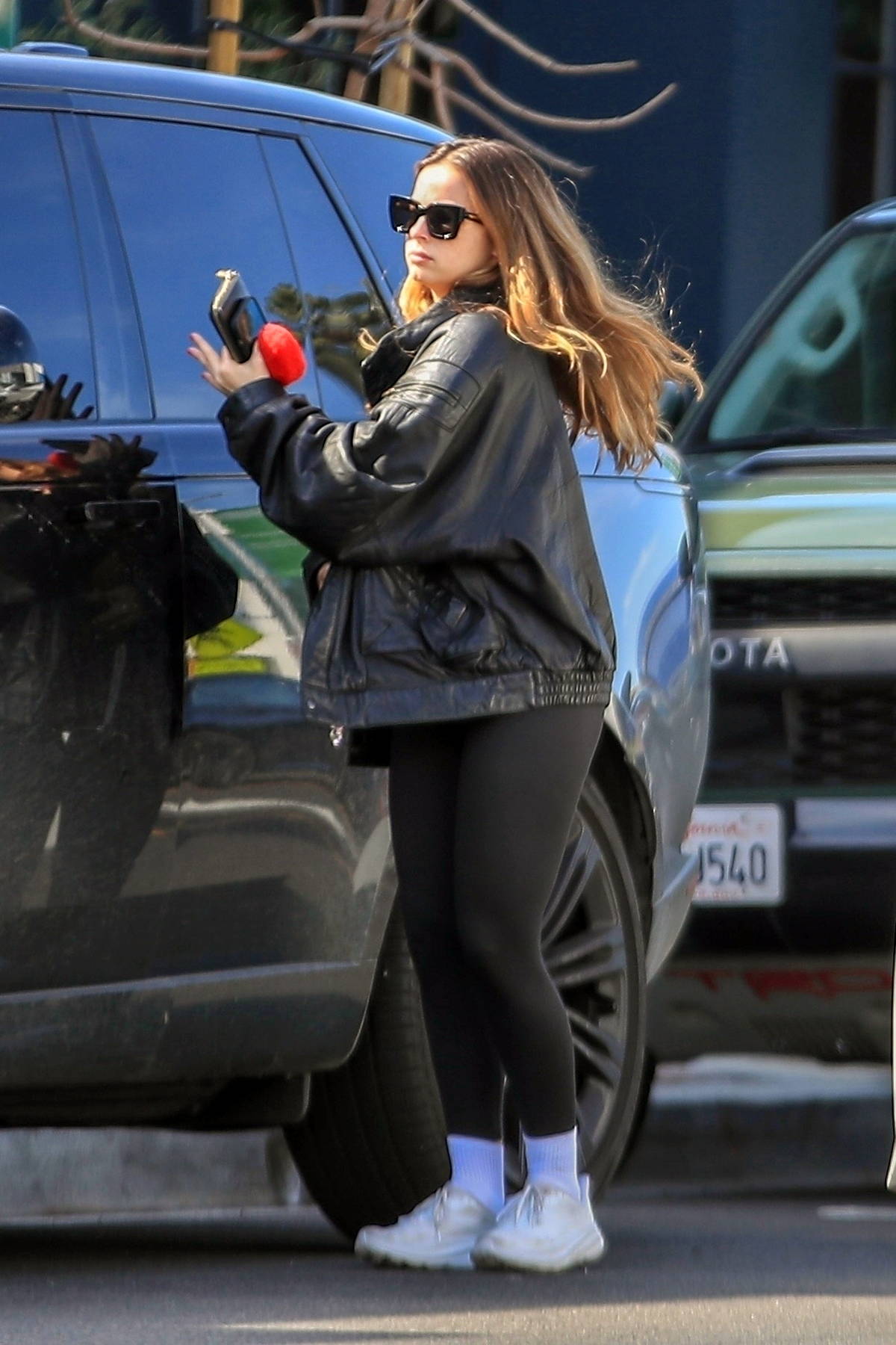 Addison Rae rocks a leather jacket and leggings while out for some