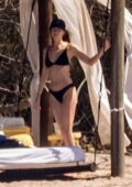 Dakota Johnson catches some sun in a black bikini while during her vacation with Chris Martin in Puerto Vallarta, Mexico