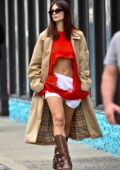 Emily Ratajkowski flashes her midriff in a ripped red sweater with white shorts while stepping out in New York City