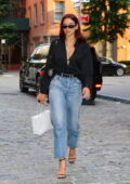 Dua Lipa cuts a stylish figure in a black shirt and blue jeans while heading out in New York City