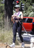 Lucy Hale displays her toned figure in a purple crop and black leggings while out on a hike with her pups in Hollywood Hills, California