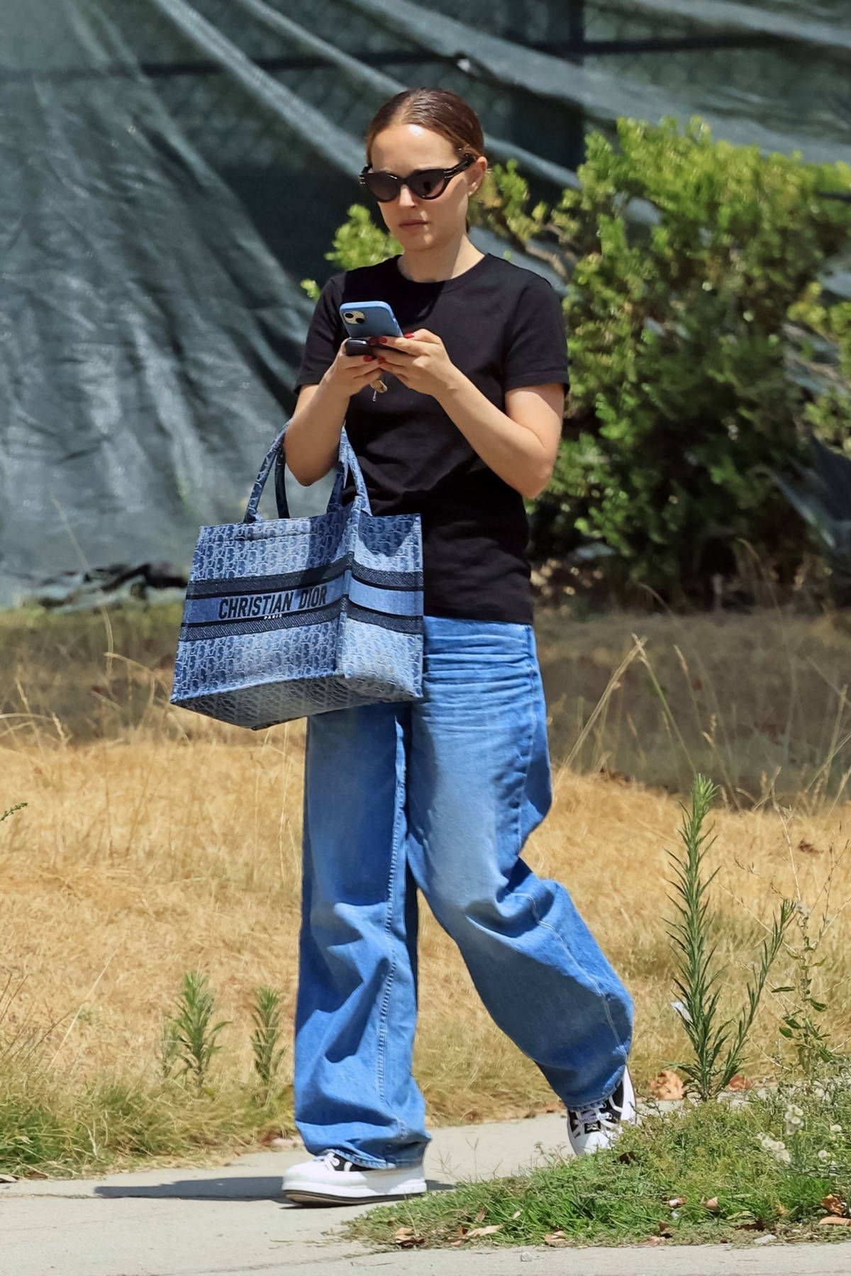 Natalie Portman running errands in blue jeans accented by Dior sneakers in Los Angeles