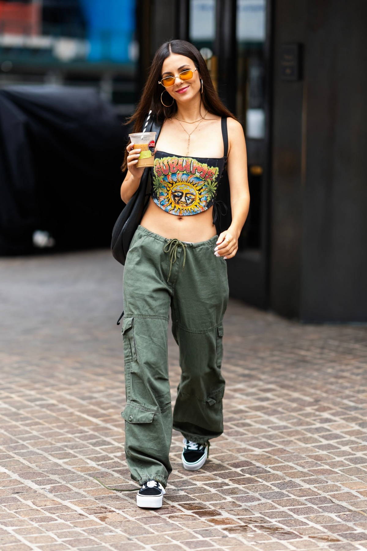 Victoria Justice flashes her toned tummy in a graphic crop top and olive green cargo pants while stepping out in New York City