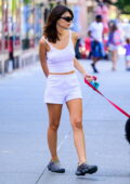 Emily Ratajkowski cuts a casual figure in a white tank top and shorts while walking her dog in New York City