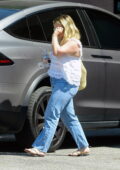 Hilary Duff wears a white top and blue jeans while seen leaving her husband Matthew Koma's studio in Los Angeles