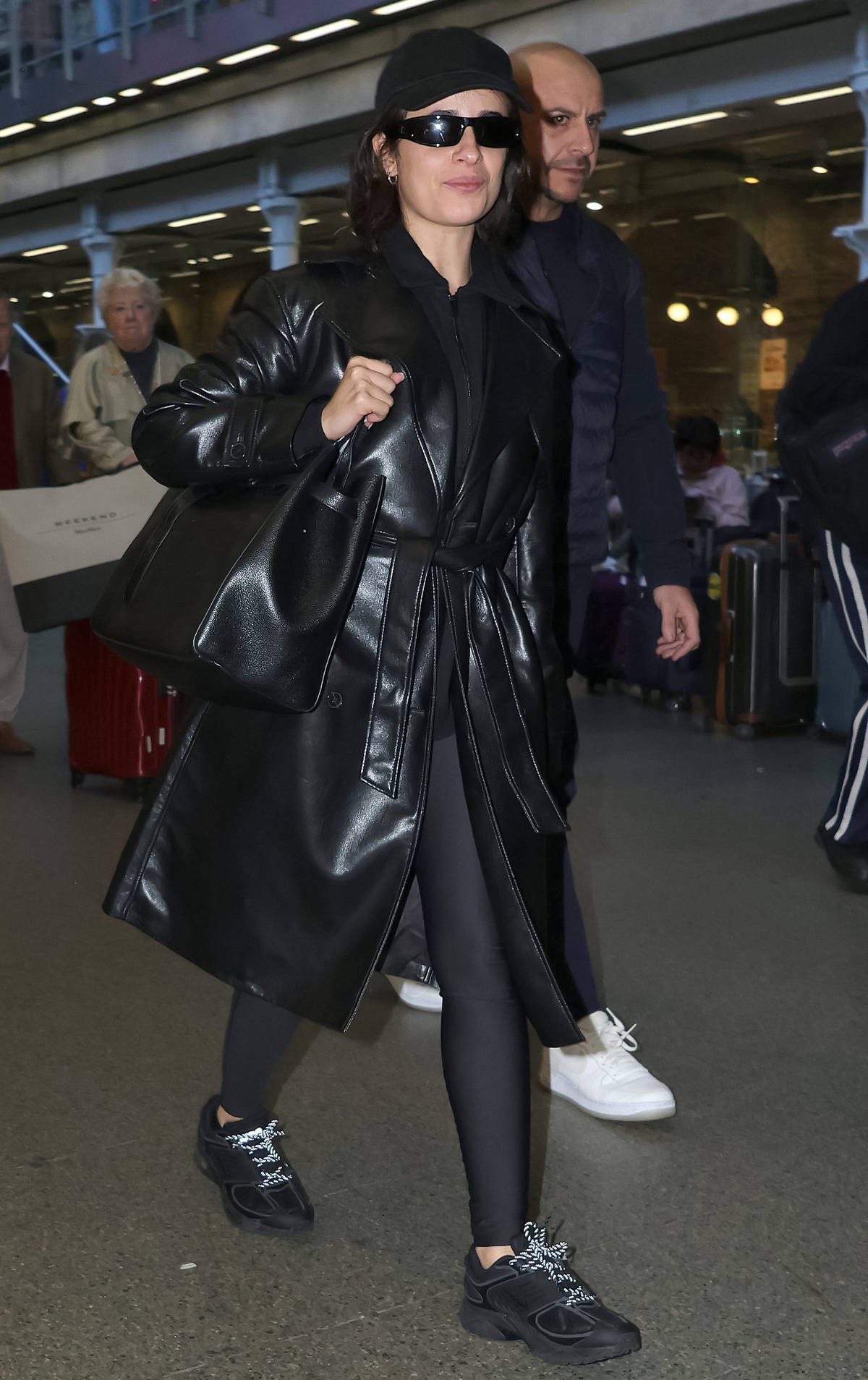 Camila Cabello dons a black leather coat and leggings while seen arriving at St Pancras International station in London, England