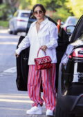 Jessica Alba dons a white shirt and pink striped pants while arriving at a friend's house for a family pizza night in Los Angeles