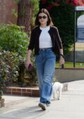 Lucy Hale wears a cardigan over a white crop top and jeans as she takes her dog out for a walk in Los Angeles